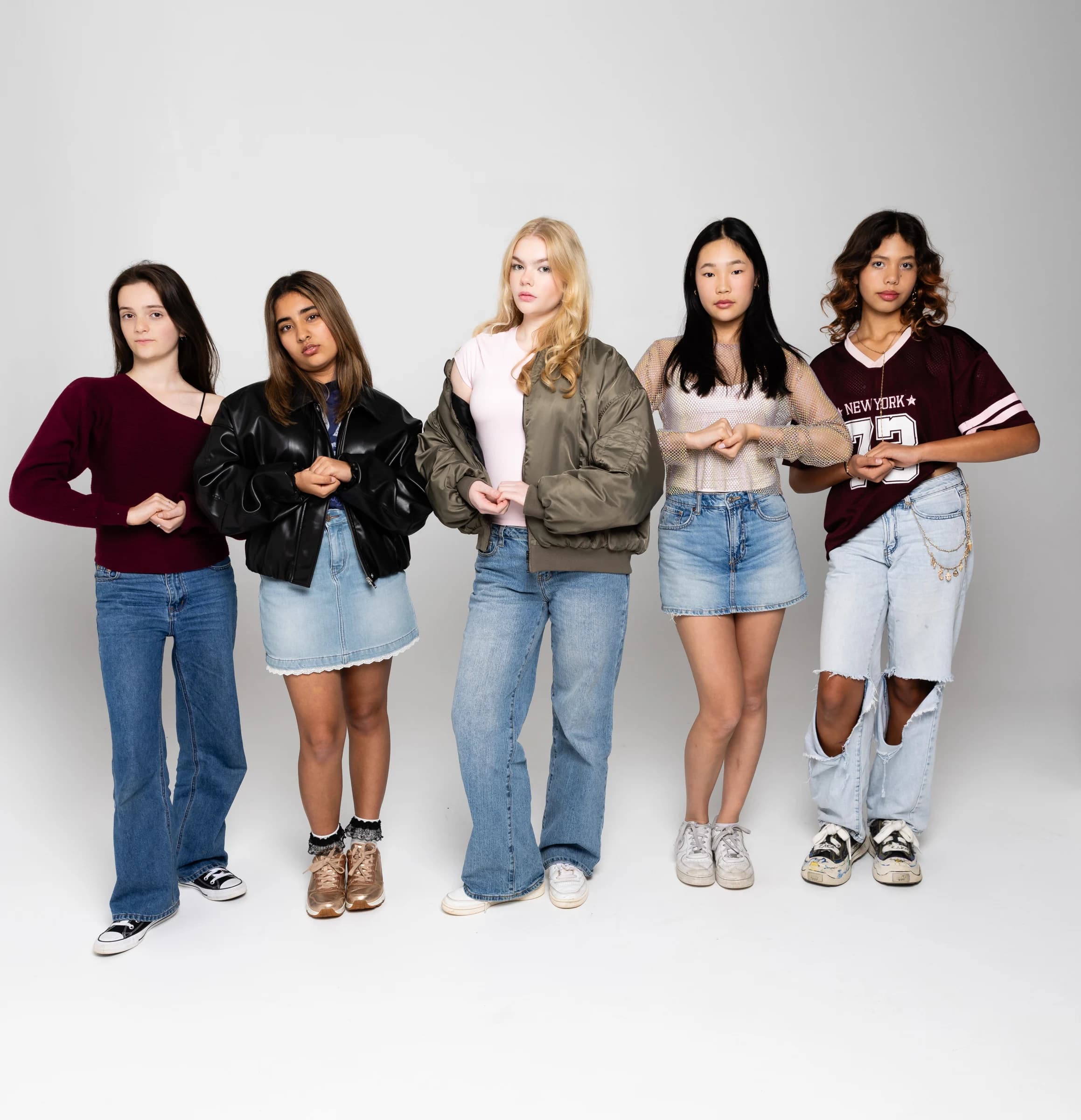 Five NVA artists standing together against a light studio background